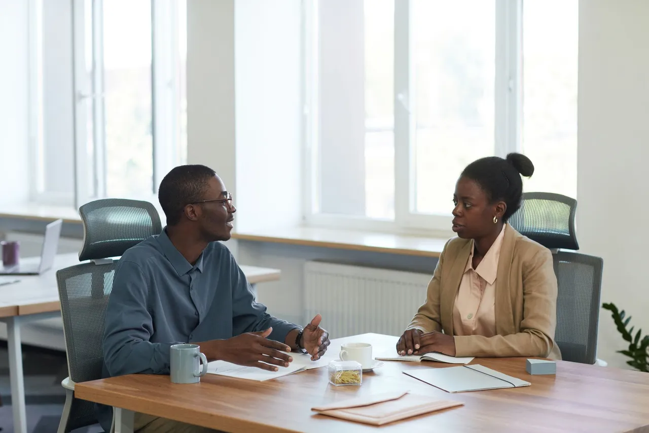 Two colleagues having a business conversation in a modern office.