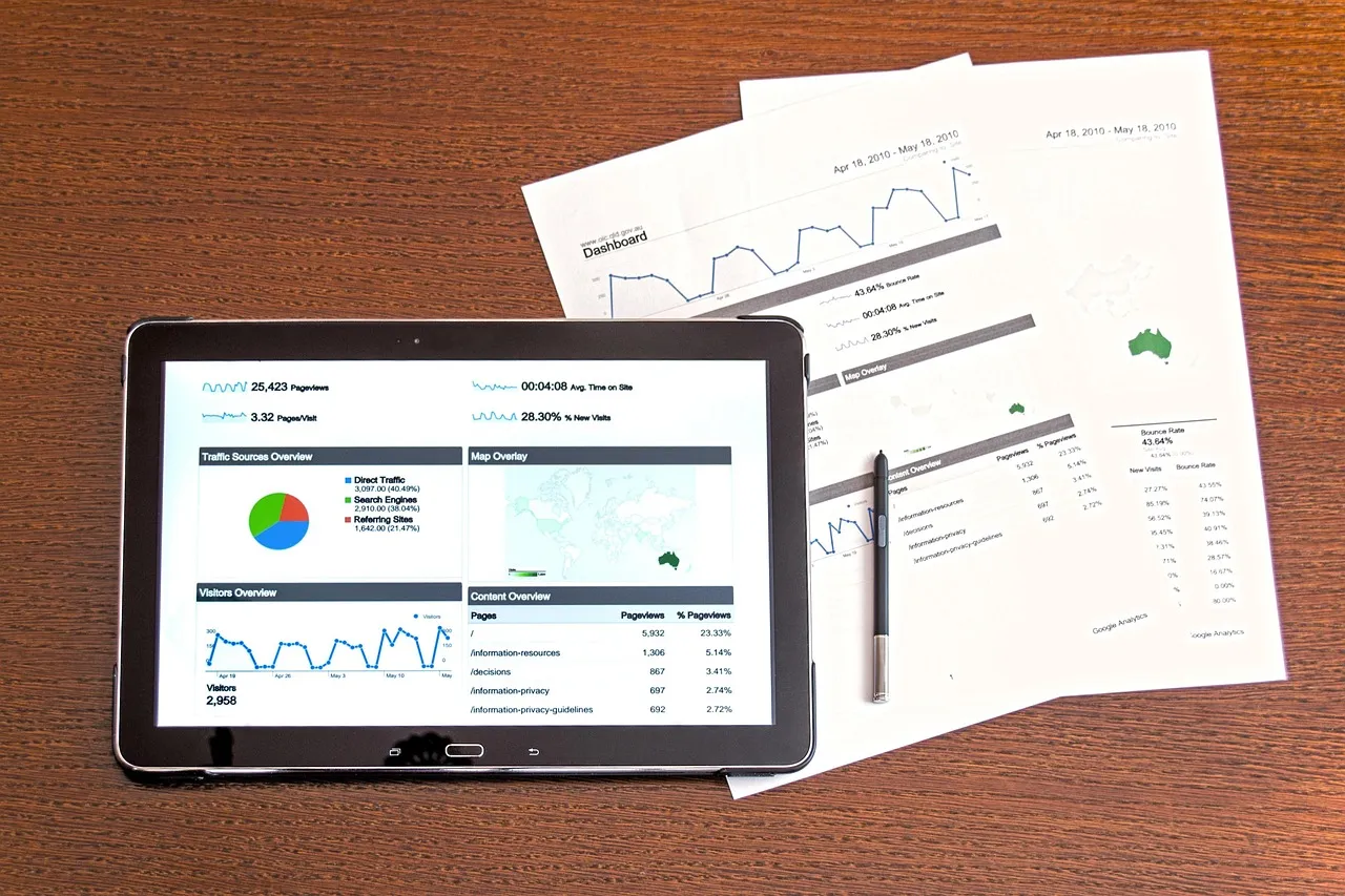 A businesswoman reviewing financial spreadsheets with charts and graphs in an office setting.