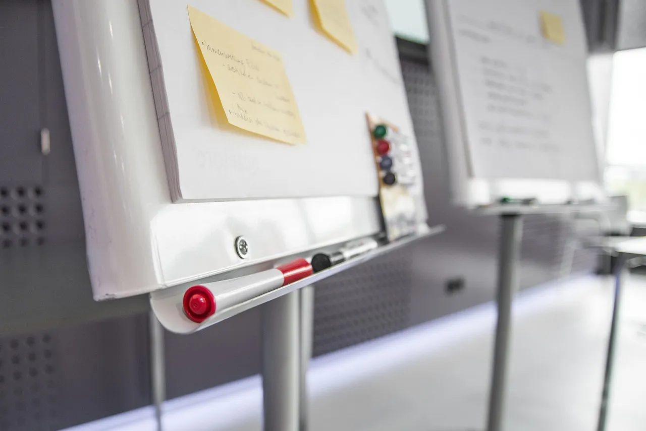 A workshop board covered with sticky notes and pens.