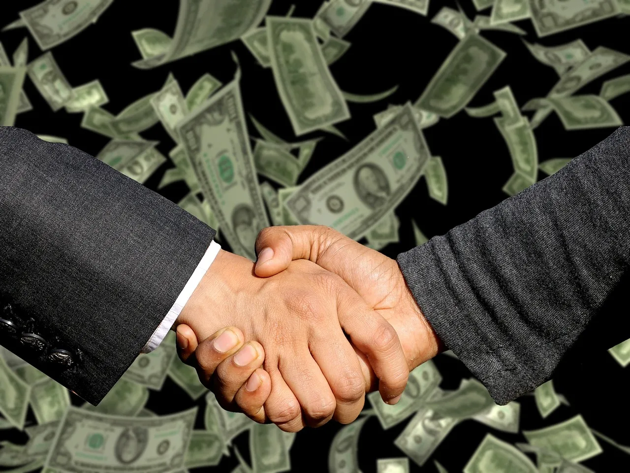 Two business partners shaking hands to seal an agreement.